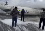 people standing next to a plane